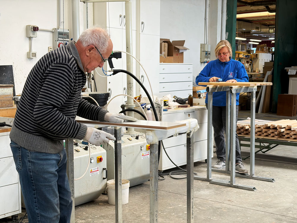 Due persone che eseguono lavorazioni manuali per produzione arredi per hotel